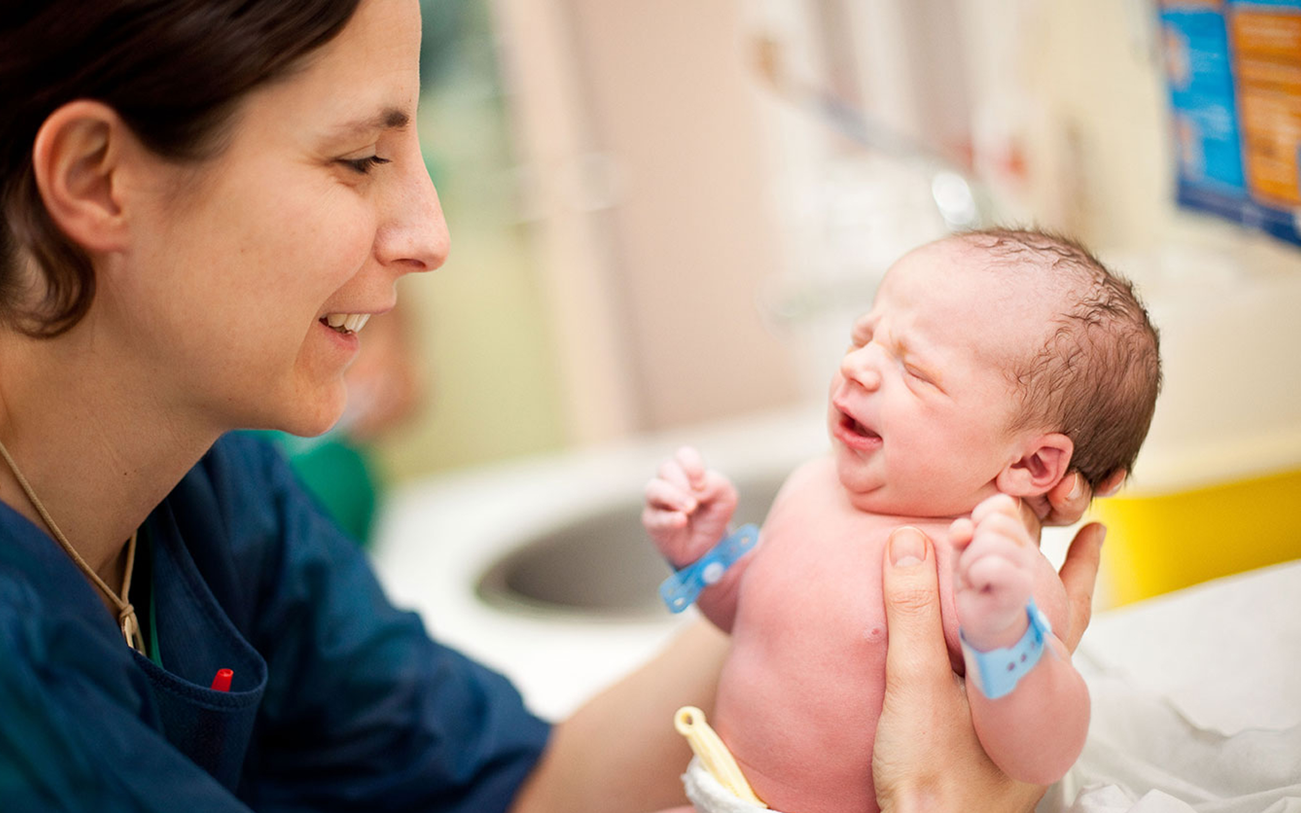 NHS_Learning-Hub_midwife-holding-a-baby